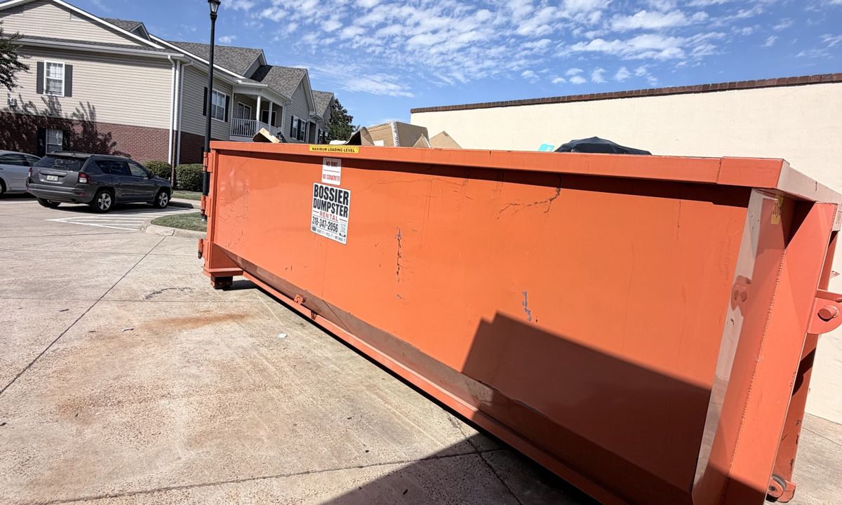 Orange 30-yard Bossier Dumpster Rental container at an apartment community