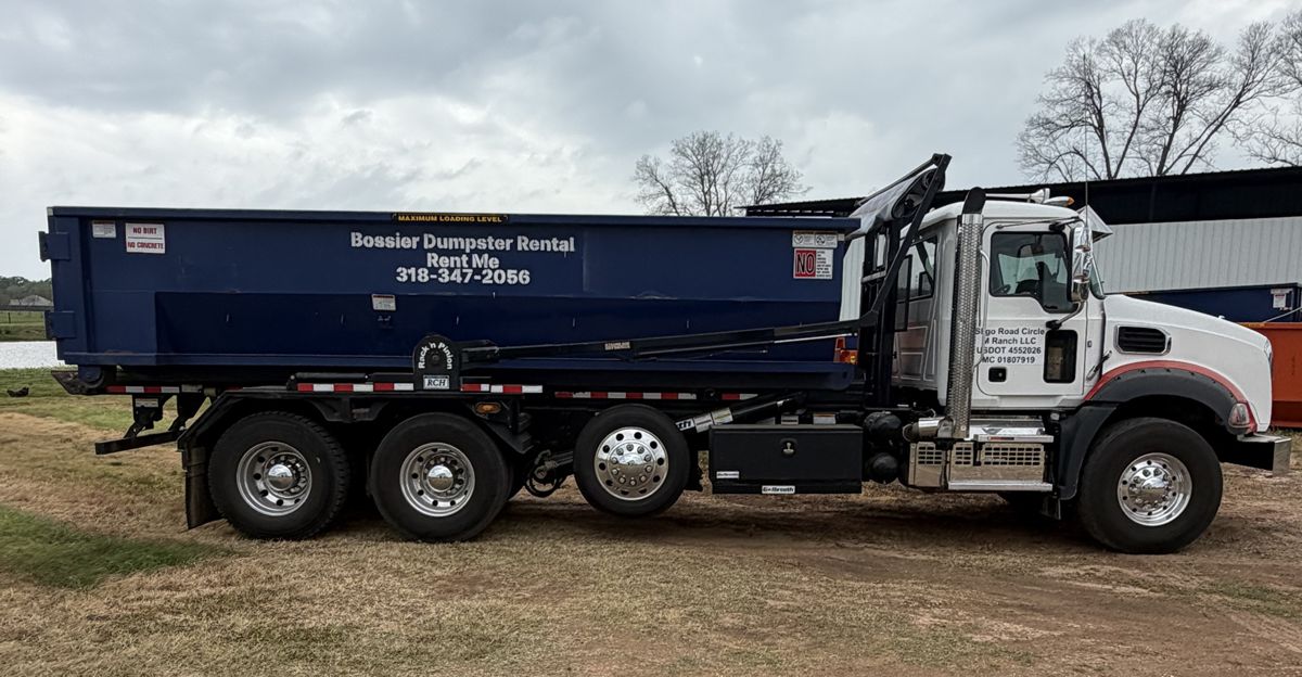 Blue Bossier Dumpster Rental container on a Mack Granite roll-off truck