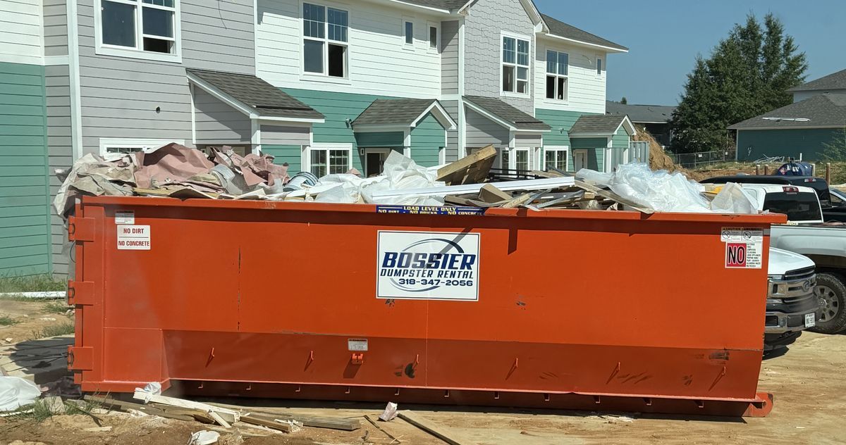 Orange Bossier Dumpster Rental container at an apartment construction site