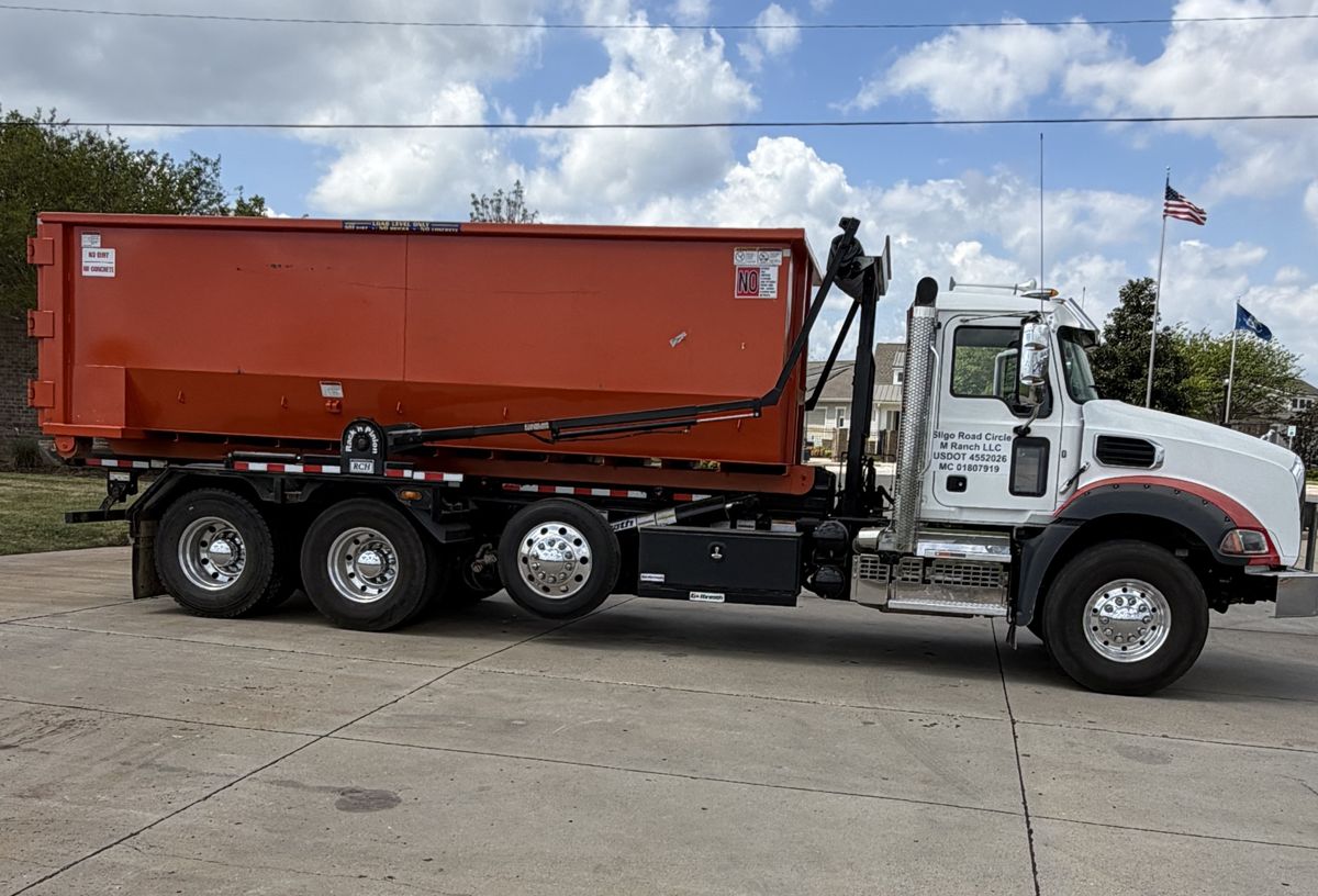 Bossier Dumpster Rental Mack Granite roll-off truck hauling an orange 30-yard dumpster in Bossier City
